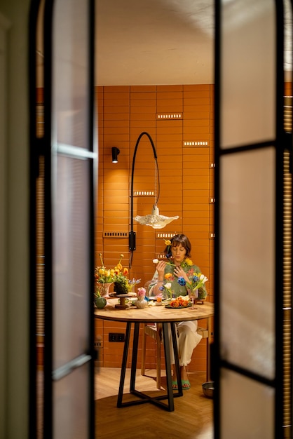 Woman eats flowers by the table