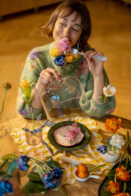 Woman eats flowers by the table