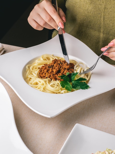 Photo woman eats her lunch in restaurant pasta with meat