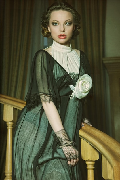 Photo woman in elegant dress posing on stairs