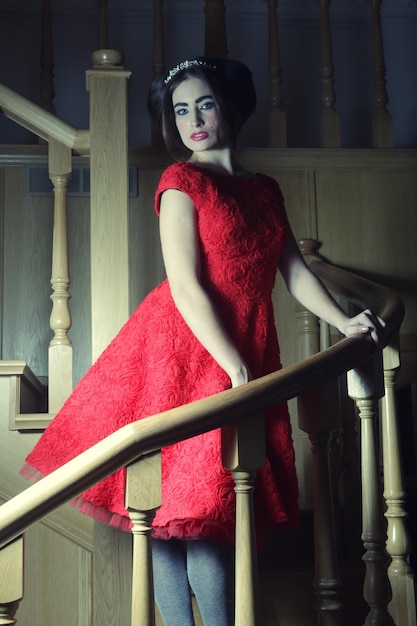 Woman in elegant dress posing on stairs