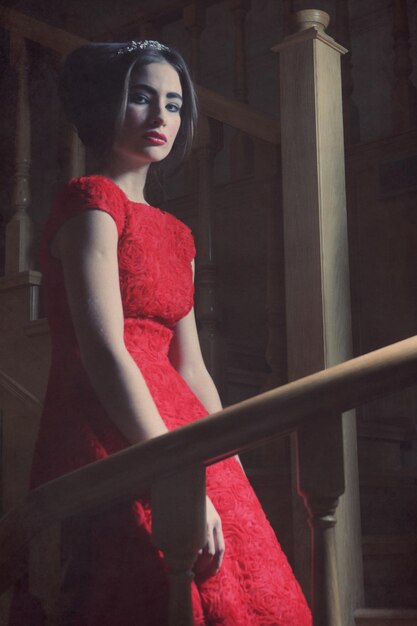 Woman in elegant dress posing on stairs