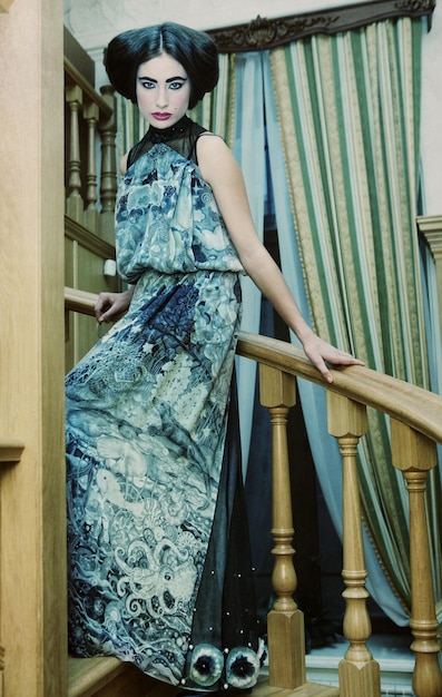 Woman in elegant dress posing on stairs