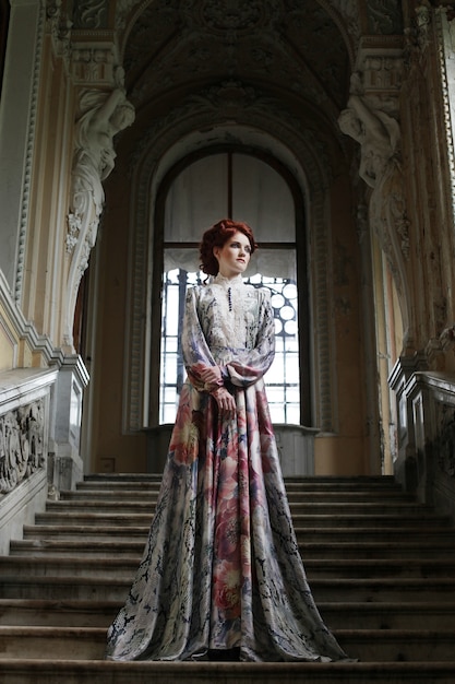 Woman in elegant dress posing on stairs