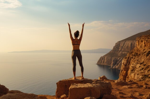 A woman embraces the freedom and conquer her fears as she stands triumphantly atop a cliff Woman attempting challenging yoga posture on a cliff edge AI Generated