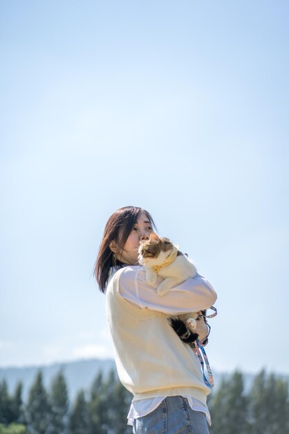 写真 外で猫を抱きしめる女性