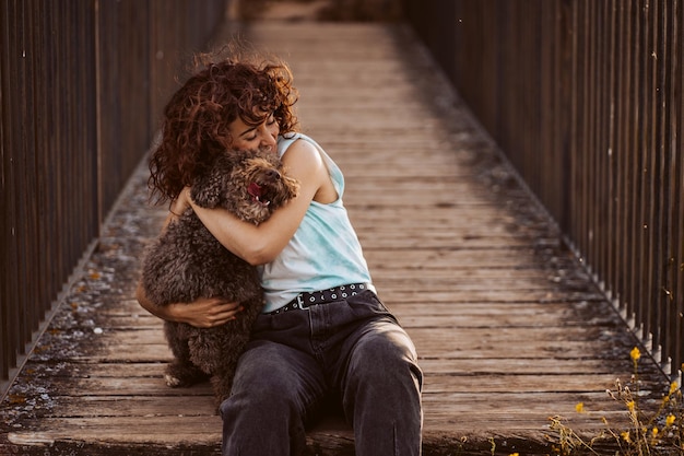 Foto donna che abbraccia un cane sul lungomare