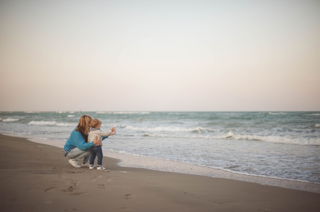 写真 海を見ながら彼女の息子を抱きしめる女性