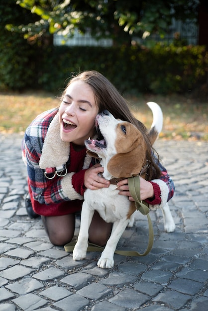 Woman embracing puppy dog outdoor happy girl gets lovely dog plays and embraces humans and dogs