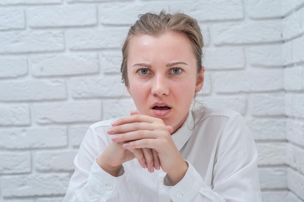 Woman emotions with white brick wall background