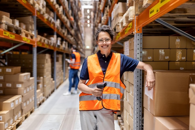 woman employee in a reflective vest working in a large warehouse