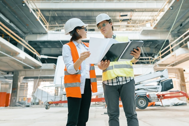 Woman engineer and man builder at construction site