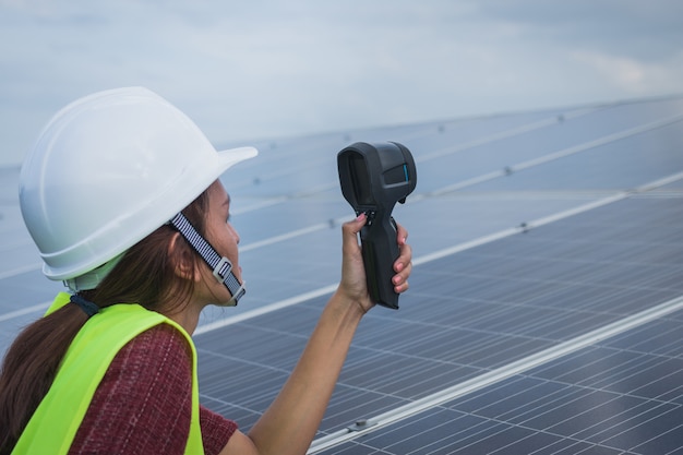 Woman engineer using thermal imager to check temperature heat of solar panel 