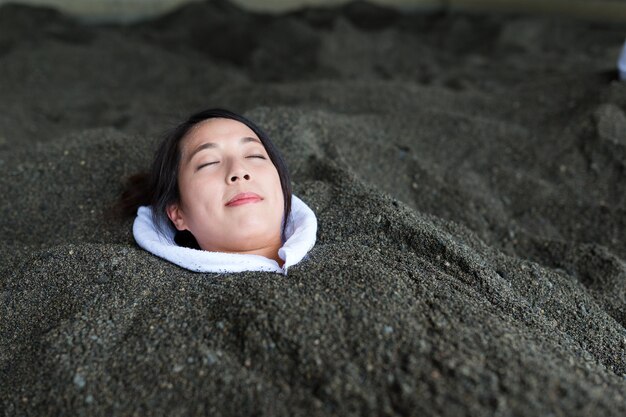 Photo woman enjoy hot sand bath