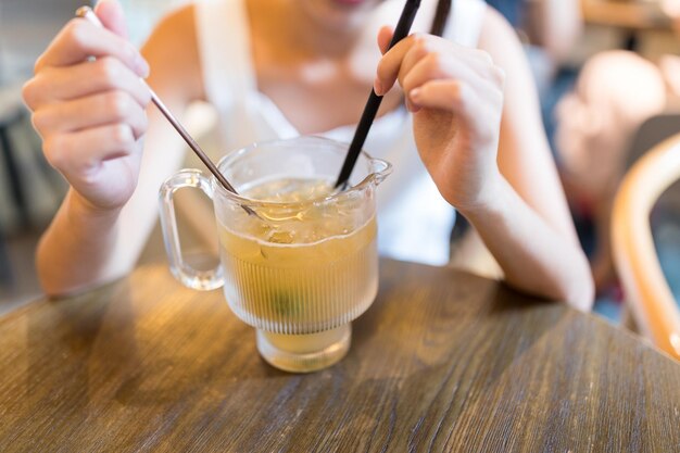 Женщина наслаждается сочным чаем со льдом в ресторане
