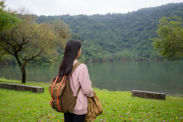 田舎の湖の景色を楽しむ女性