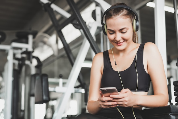 Woman enjoy listening music in gym