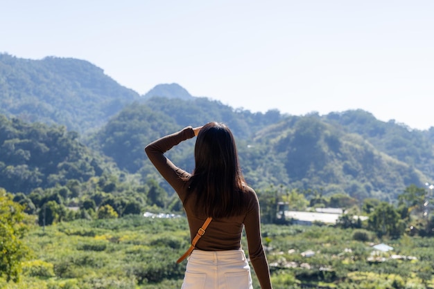 女性は田舎の山の景色を楽しんでいます