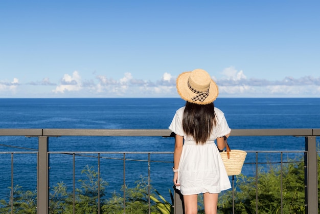 女性は晴れた日に海の景色を楽しむ