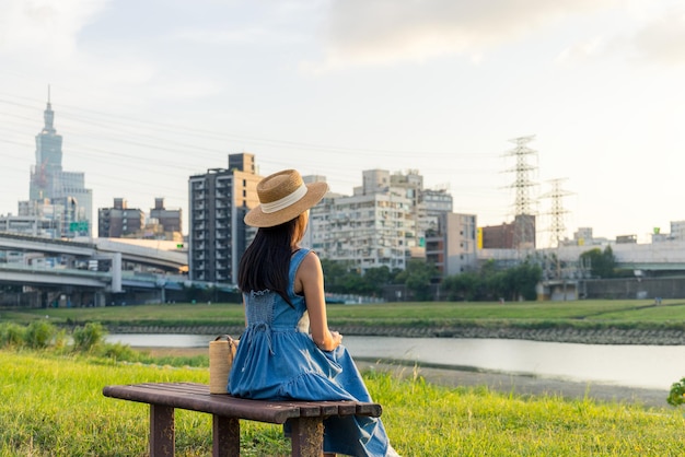 女性が台北市の川辺の公園で日没の景色を楽しんでいます