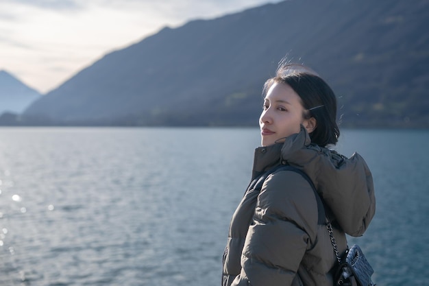 여자는 스위스의 브리엔츠 호수(Lake Brienz)에서 이젤발트(Iseltwald)의 산과 호수를 즐깁니다.