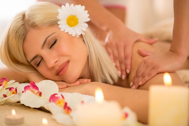 Woman enjoying during a back massage at a spa. Close-up.