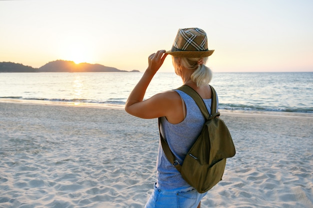 Foto donna che gode del bellissimo tramonto sulla spiaggia.