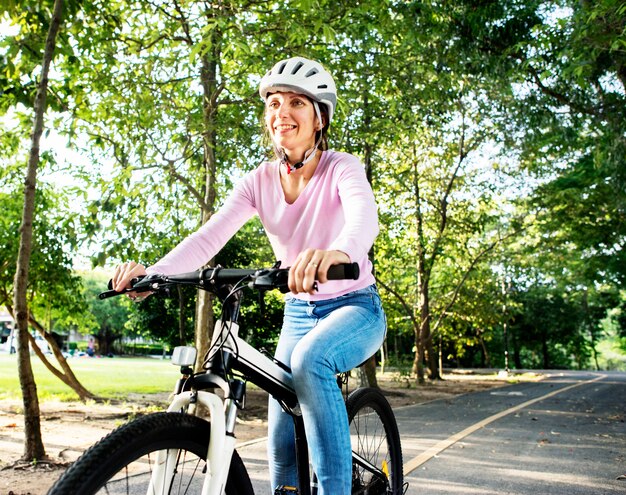 Foto donna che gode di un giro in bicicletta nel parco