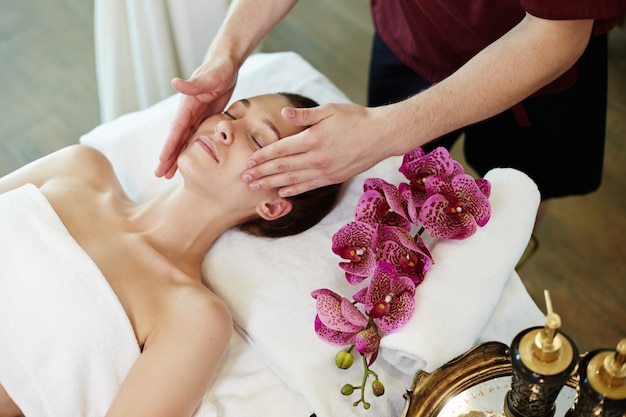 Woman Enjoying Facial Massage in SPA