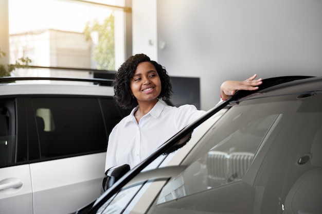 Foto donna che gode della sua indipendenza finanziaria durante l'acquisto di un'auto