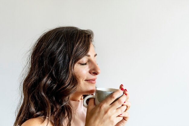 彼女の朝のコーヒーを楽しんでいる女性