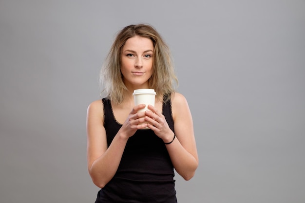 Woman enjoying hot drink in disposable paper cup