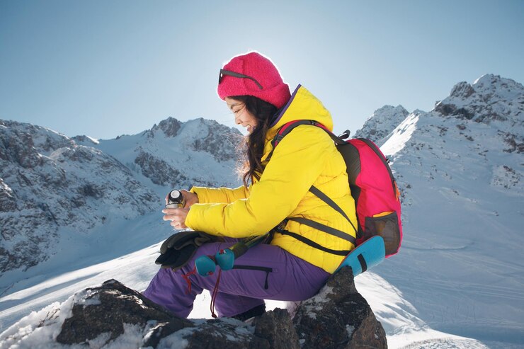 Photo woman enjoying hot tea on snowcovered mountain slope during sunny day