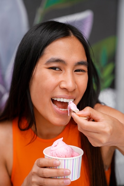 Foto donna che gode del gelato fuori