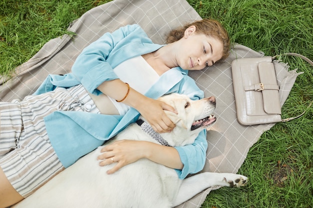 犬と一緒にピクニックを楽しむ女性