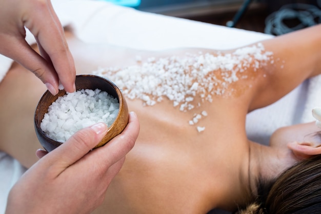 Photo woman enjoying a salt scrub massage