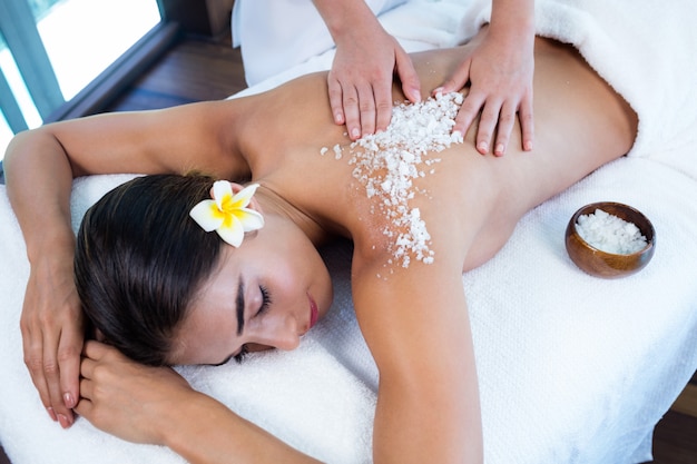 Photo woman enjoying a salt scrub massage