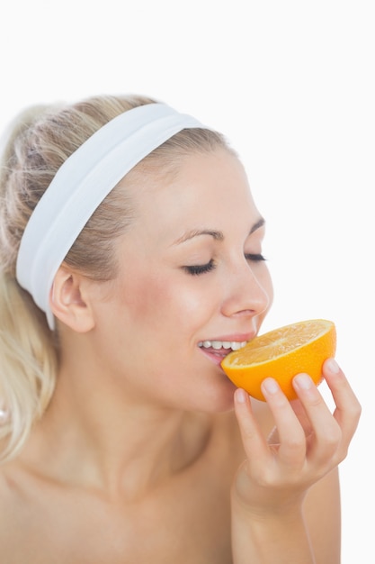 Woman enjoying slice of orange