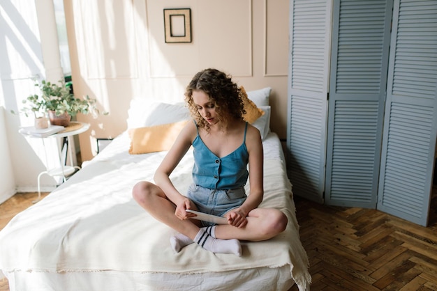 Woman enjoying time working on digital tablet at her home