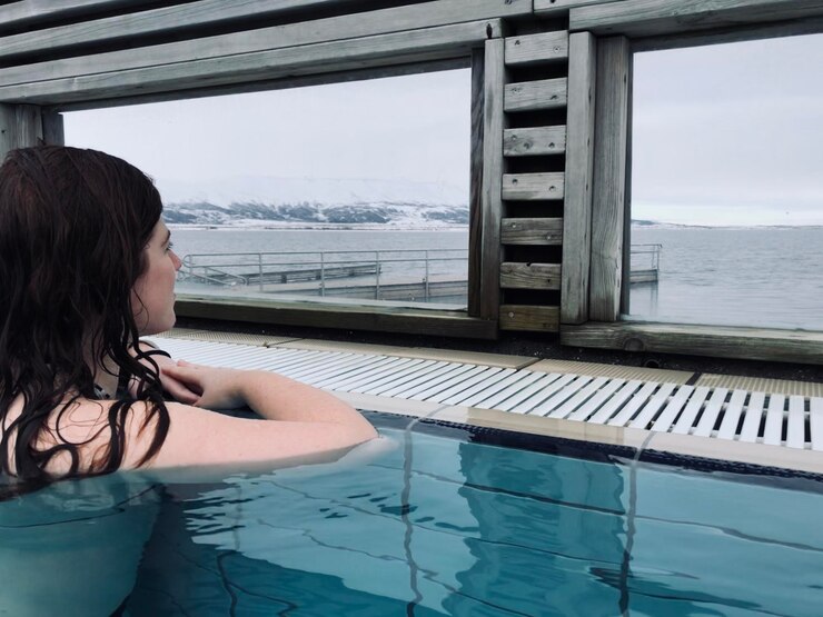 Photo a woman enjoying the view in icelandic natural spring pool in laugarvatn fontana iceland