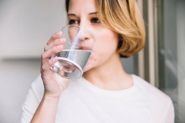 写真 窓の近くで水を楽しむ女性