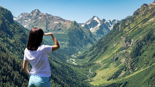 La donna gode di una bellissima vista delle montagne e del cielo blu da un'altezza