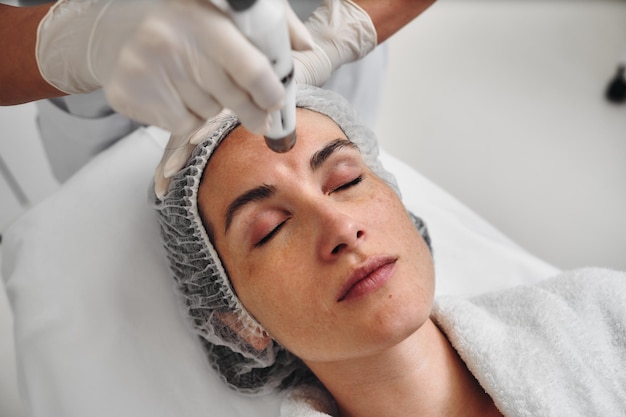 a woman enjoys a relaxing skincare session while lying on a treatment bed