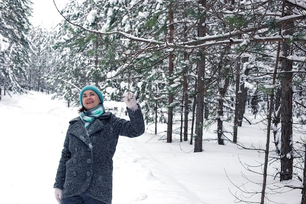 A woman enjoys a winter frosty day a walk in a pine forest