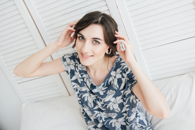 Woman enthusiastically listens to music in headphones with lapto