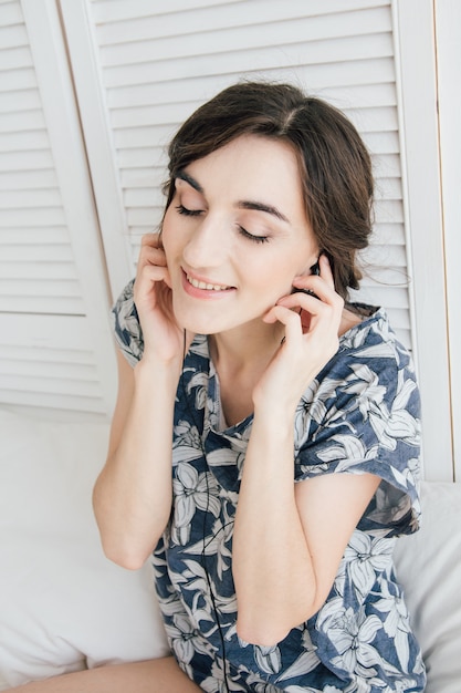 Woman enthusiastically listens to music in headphones with lapto