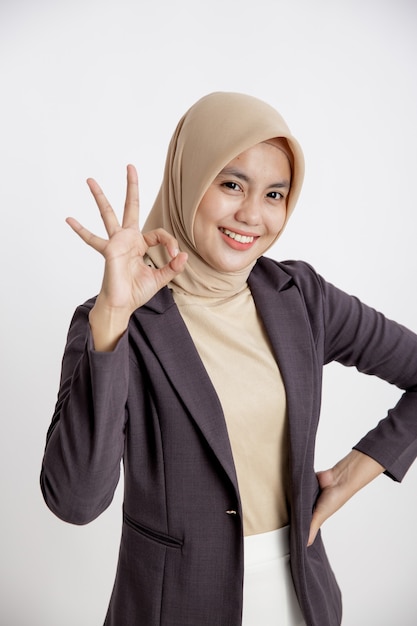 Woman entrepreneur wearing hijab OK sign hand pose, office work concept isolated white background