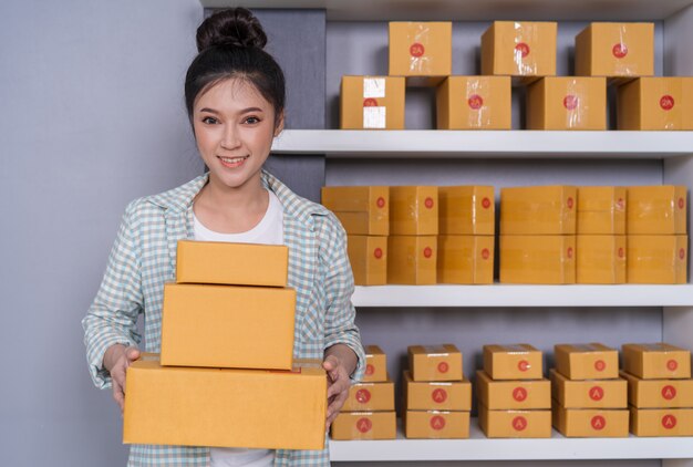 Woman entrepreneur with parcel boxes in her own job shopping online business at home