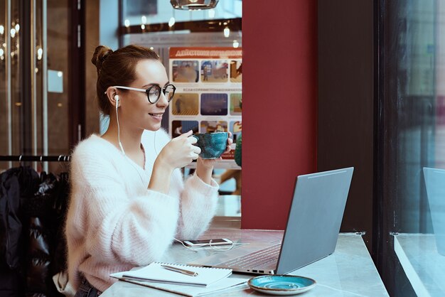 カフェから働いて、携帯電話で話している女性起業家