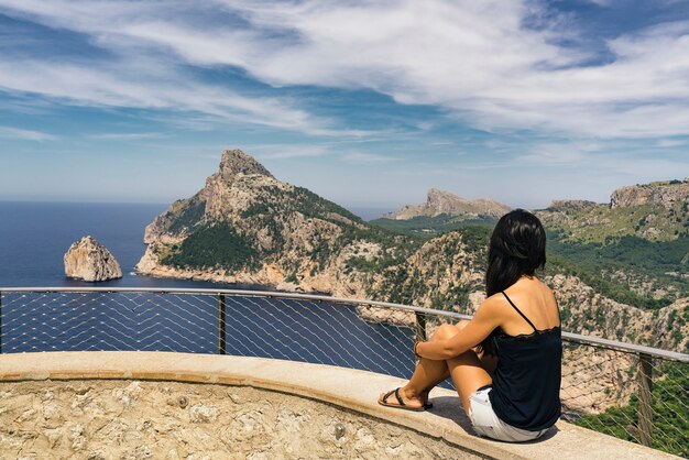 Woman in es colomer balcony looking cape formentor view in majorca, spain.